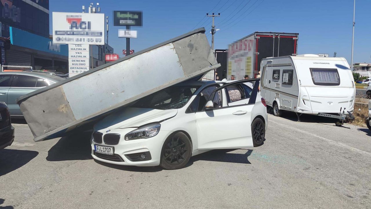 Üzerine reklam totemi devrilen otomobilin sürücüsü yara almadan kurtuldu